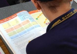 back of student reading maths book